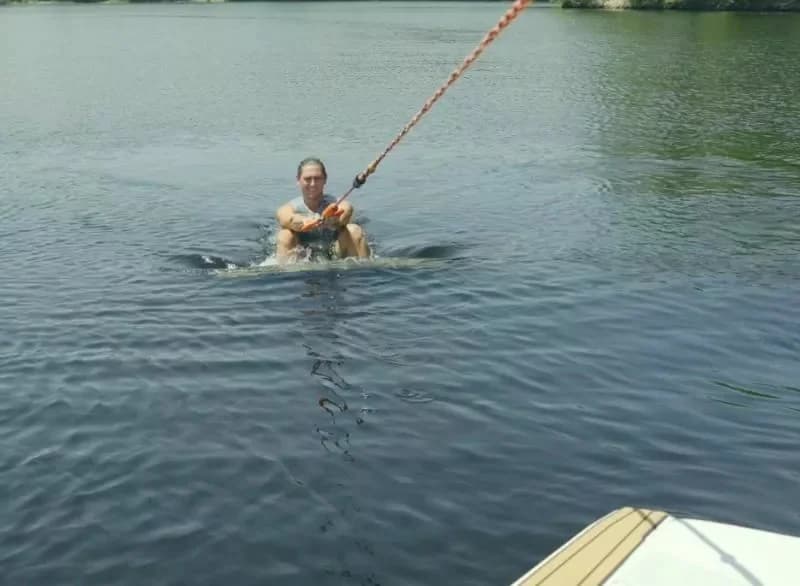 Beginner wakesurfer holding the rope while learning to get up behind the boat
