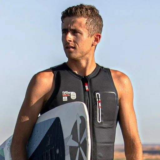 Parker Payne holding a board by the water.
