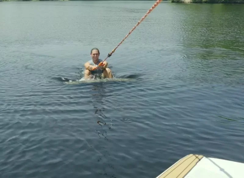 Beginner wakesurfer riding behind a boat while learning proper position on the wave